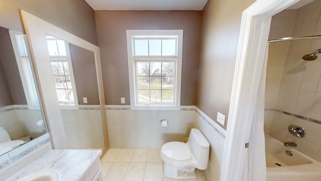 full bathroom with tile walls, tiled shower / bath, toilet, tile patterned floors, and vanity