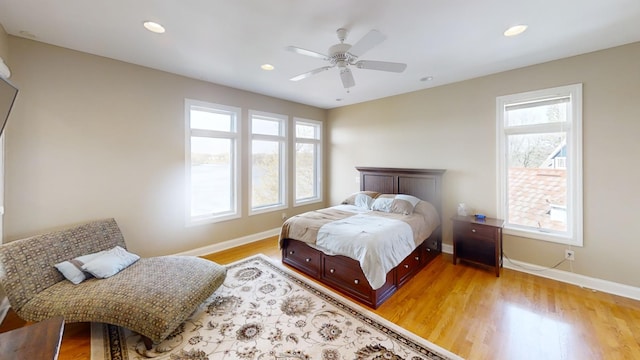 bedroom with light hardwood / wood-style floors, multiple windows, and ceiling fan