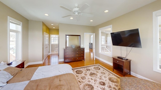 bedroom with ensuite bath, ceiling fan, and wood-type flooring