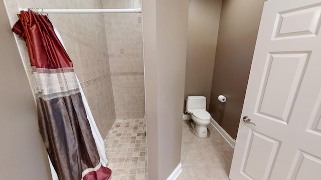 bathroom featuring tile patterned flooring, a shower with curtain, and toilet