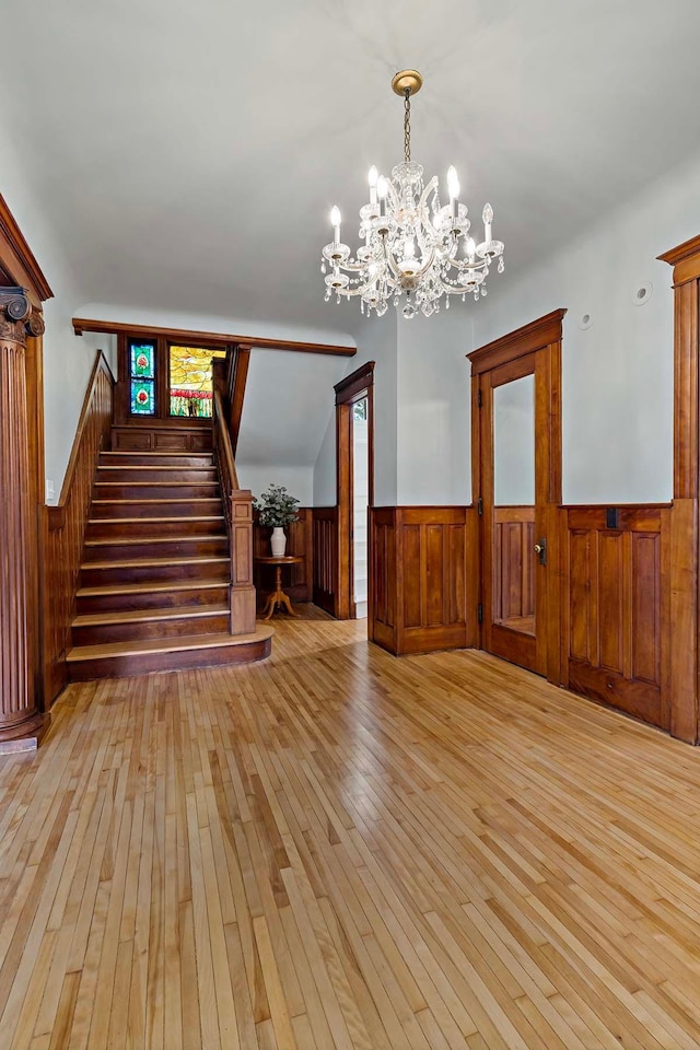 foyer with light wood-type flooring, lofted ceiling, and a notable chandelier