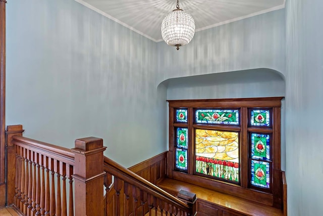 staircase with an inviting chandelier and ornamental molding