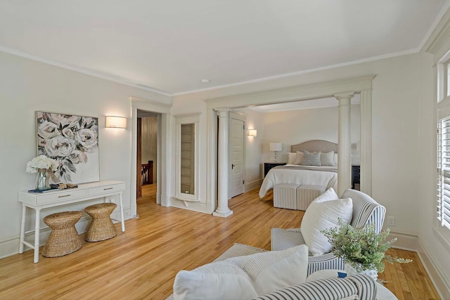 bedroom with decorative columns, light hardwood / wood-style floors, and crown molding