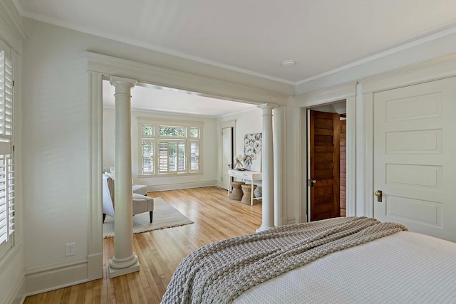 bedroom with ornamental molding, light hardwood / wood-style floors, and decorative columns