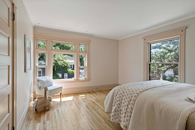 bedroom with light wood-type flooring and crown molding