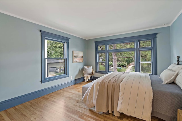 bedroom with light hardwood / wood-style flooring and crown molding