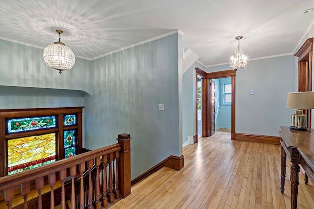 hallway featuring ornamental molding, an inviting chandelier, and light hardwood / wood-style floors