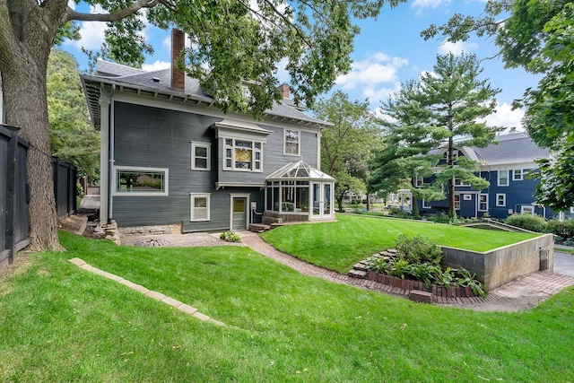 back of property featuring a lawn and a gazebo