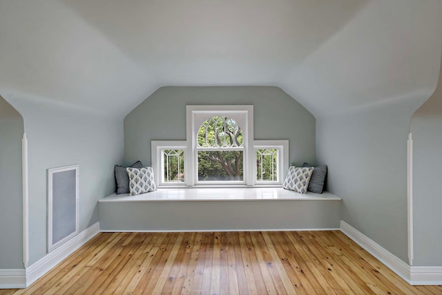 additional living space featuring light wood-type flooring and lofted ceiling