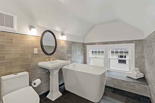 bathroom featuring toilet and tile walls