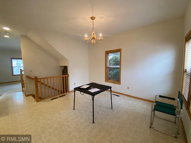 recreation room featuring vaulted ceiling, an inviting chandelier, and plenty of natural light