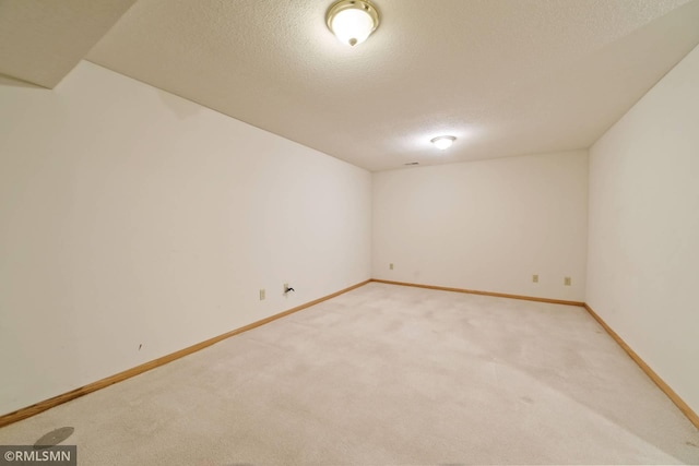 unfurnished room with a textured ceiling and carpet flooring