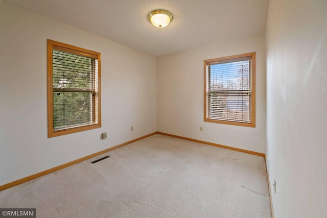 unfurnished room featuring light colored carpet