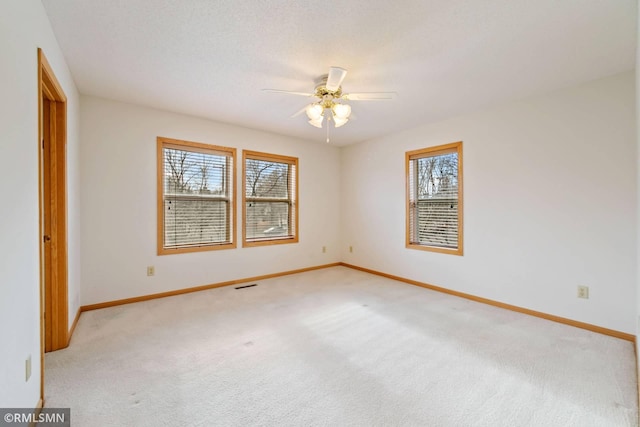 carpeted spare room featuring ceiling fan and a healthy amount of sunlight