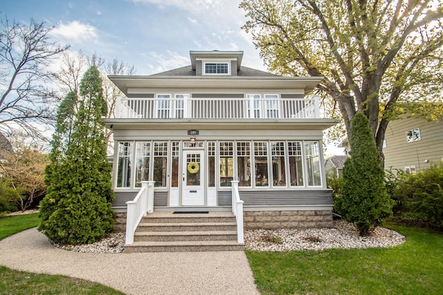 view of front of property featuring a balcony and french doors