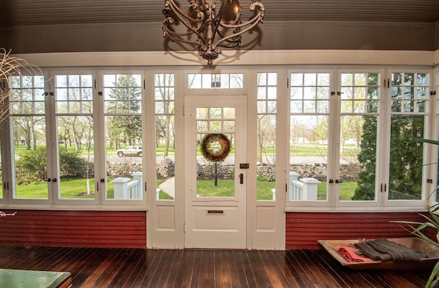 doorway featuring dark hardwood / wood-style floors, a wealth of natural light, and an inviting chandelier