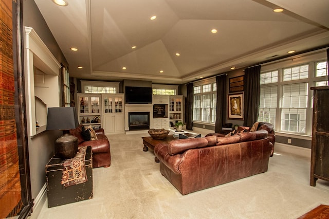 living room with built in shelves, light colored carpet, and a tray ceiling