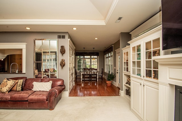 living room with vaulted ceiling, crown molding, and hardwood / wood-style floors