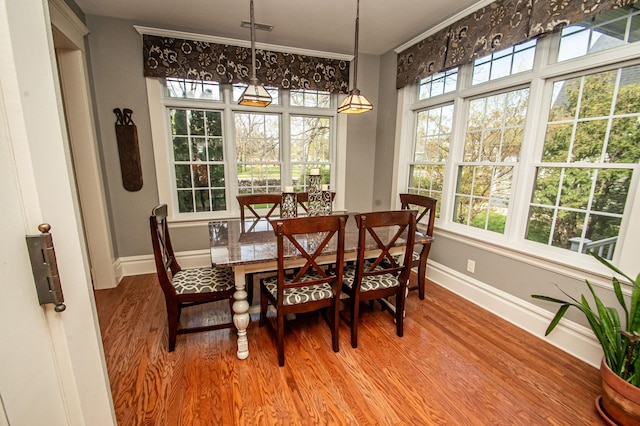 dining area featuring crown molding and hardwood / wood-style floors