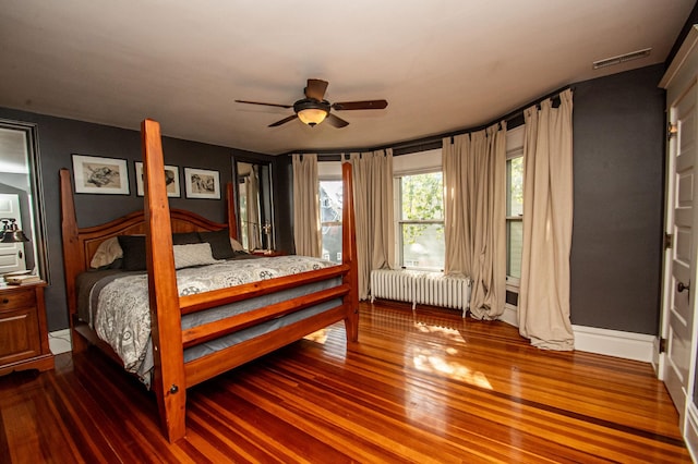 bedroom featuring radiator heating unit, ceiling fan, and hardwood / wood-style flooring