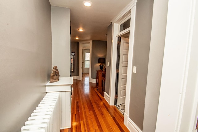 corridor featuring dark wood-type flooring and radiator