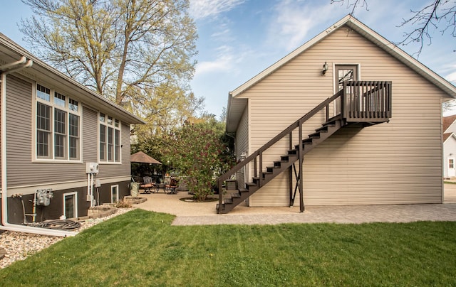 back of property with a patio area and a lawn