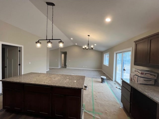 kitchen featuring light stone countertops, dark brown cabinets, carpet floors, lofted ceiling, and an inviting chandelier