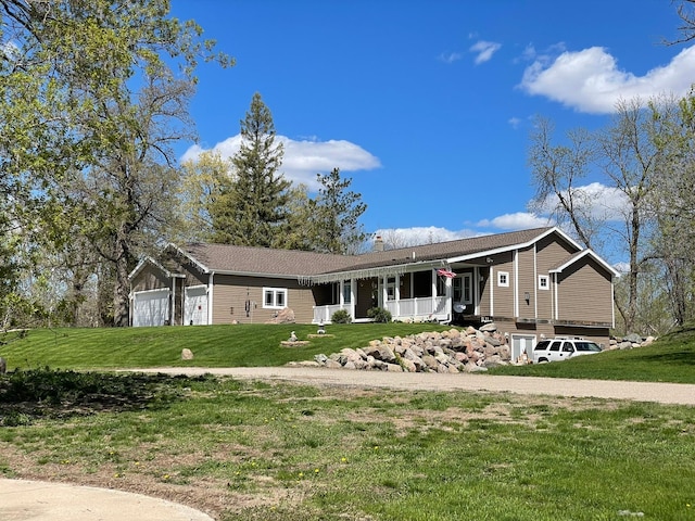 single story home with a garage, a front yard, and covered porch