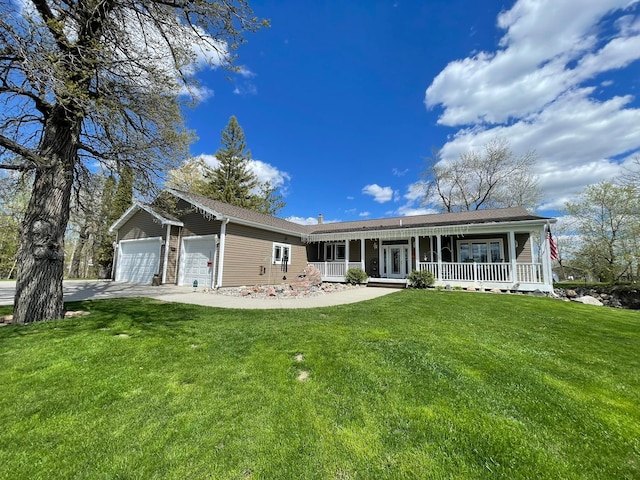 view of front of property featuring covered porch, a garage, and a front yard