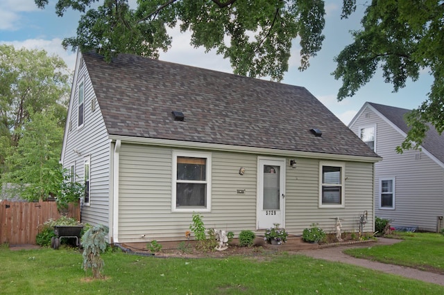 cape cod home featuring a front lawn