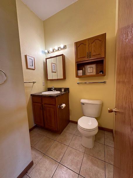 bathroom with vanity, tile patterned flooring, and toilet