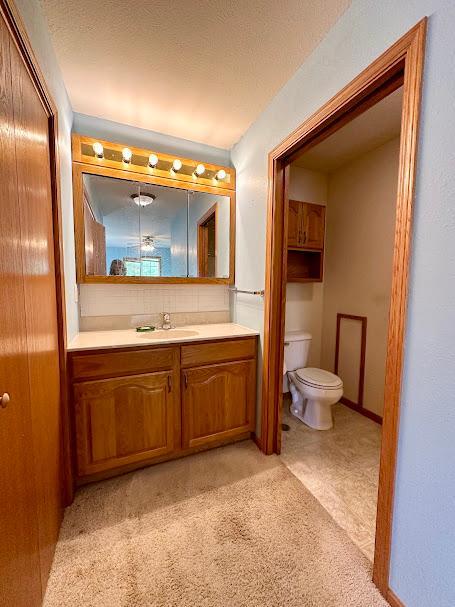 bathroom with vanity, toilet, and a textured ceiling