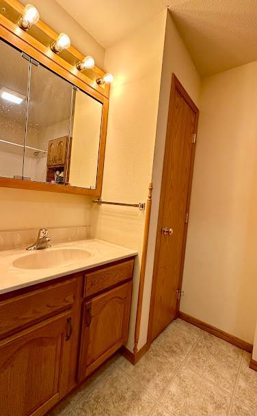 bathroom featuring vanity, a textured ceiling, and tile patterned floors