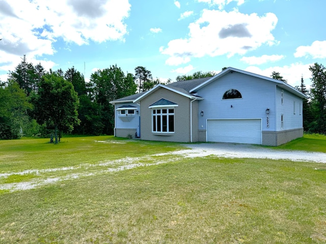 view of front of home with gravel driveway, a front yard, and a garage