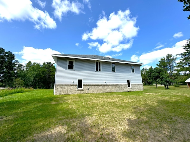 rear view of house featuring a lawn