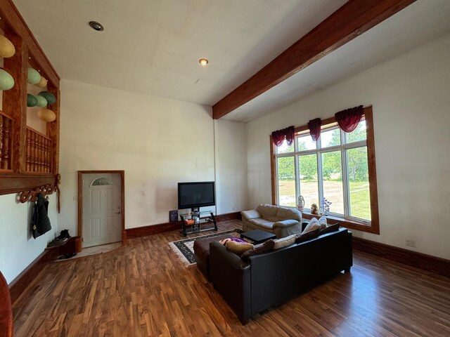 living room with beamed ceiling and dark wood-type flooring