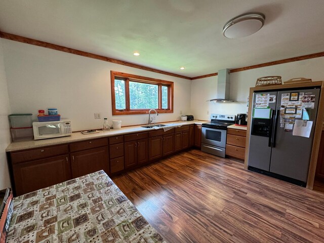 kitchen with dark hardwood / wood-style flooring, stainless steel appliances, wall chimney exhaust hood, dark brown cabinetry, and sink