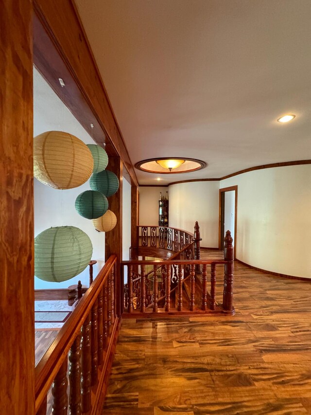 hall with wood-type flooring and ornamental molding