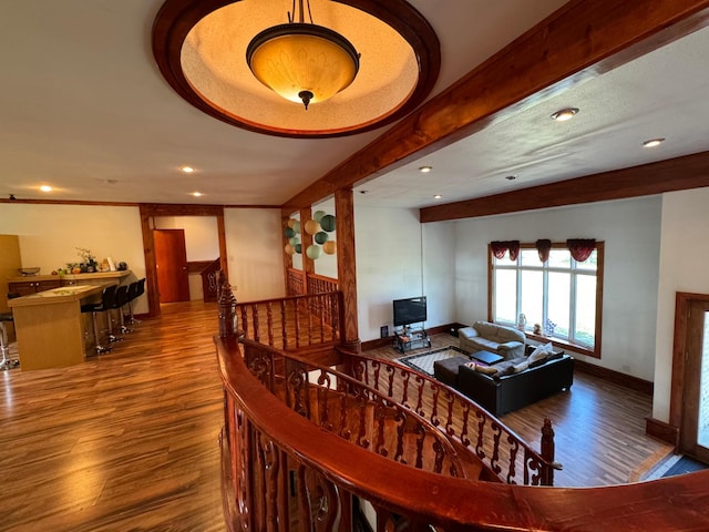 interior space with beam ceiling, wood finished floors, recessed lighting, stairway, and baseboards