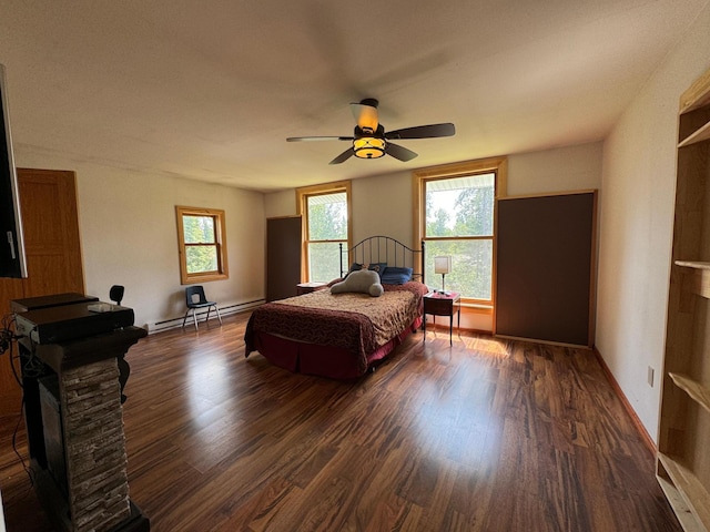 bedroom featuring baseboards, a baseboard heating unit, ceiling fan, and wood finished floors