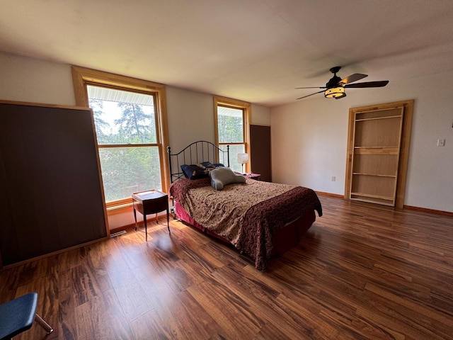 bedroom with ceiling fan, baseboards, and wood finished floors