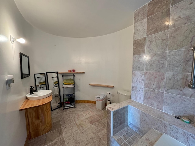 bathroom with toilet, vanity, and baseboards