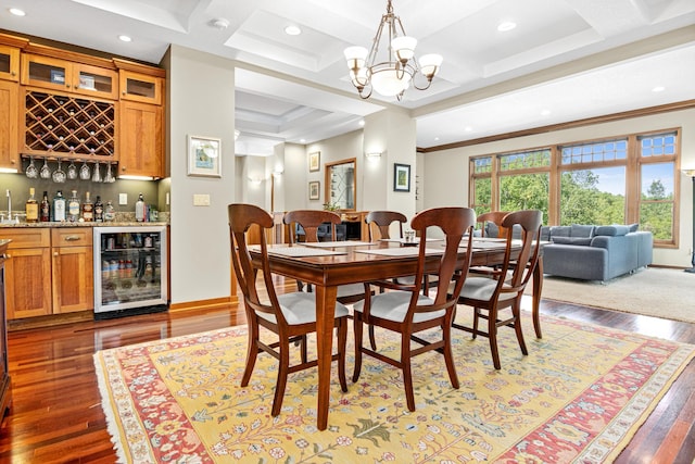 dining area with coffered ceiling, wine cooler, hardwood / wood-style floors, and an inviting chandelier