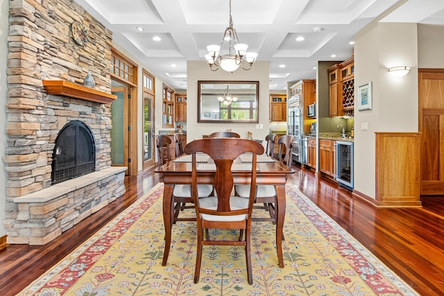 dining area with a fireplace, coffered ceiling, hardwood / wood-style flooring, and wine cooler