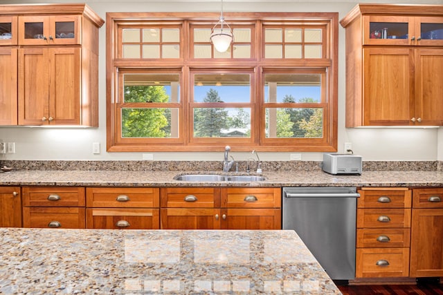 kitchen featuring a wealth of natural light, stainless steel dishwasher, sink, and hanging light fixtures