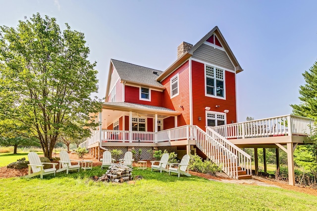 rear view of property featuring a deck and a lawn