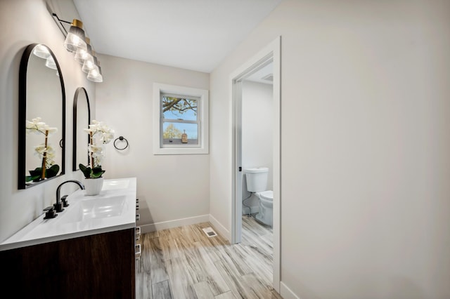 bathroom featuring vanity, toilet, and wood-type flooring