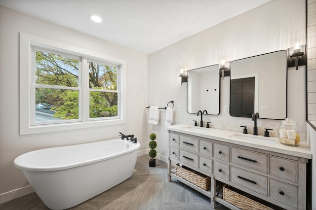 bathroom with parquet floors, vanity, and a tub