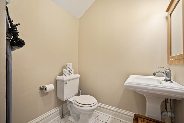 2799 27th St Unit 14, Gardeners, Birchwood, WI 54817 - bathroom featuring toilet, baseboards, lofted ceiling, tile patterned floors, and a sink