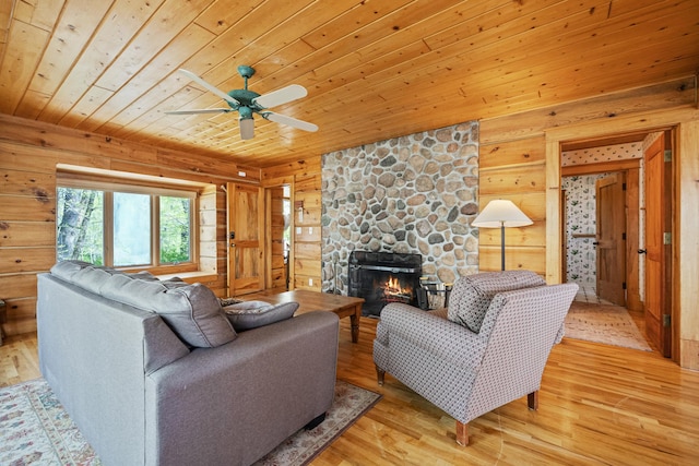 2799 27th St Unit 8, Katherine, Birchwood, WI 54817 - living room with wooden ceiling, a stone fireplace, wood walls, light wood finished floors, and a ceiling fan